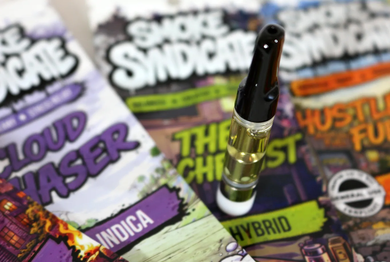 Smoke Syndicate cannabis cartridge on colorful flavor packaging